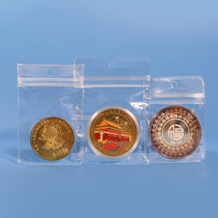 Clear PVC hanging hole ziplock bags protecting gold and silver commemorative coins.