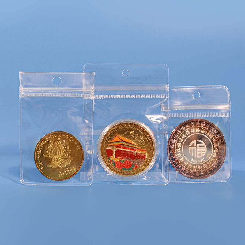 Clear PVC hanging hole ziplock bags protecting gold and silver commemorative coins.