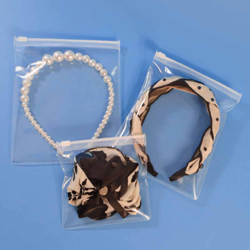 Flat lay of clear EVA zipper bags used for scrunchies and hair tie packaging.
