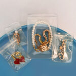 Wholesale blank anti-tarnish sealing bags on a blue tray, protecting necklaces and earrings for e-commerce jewelry fulfillment