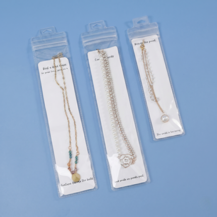 Clear PVC hanging hole ziplock pudding bags packaging necklaces with display cards on a woven mat