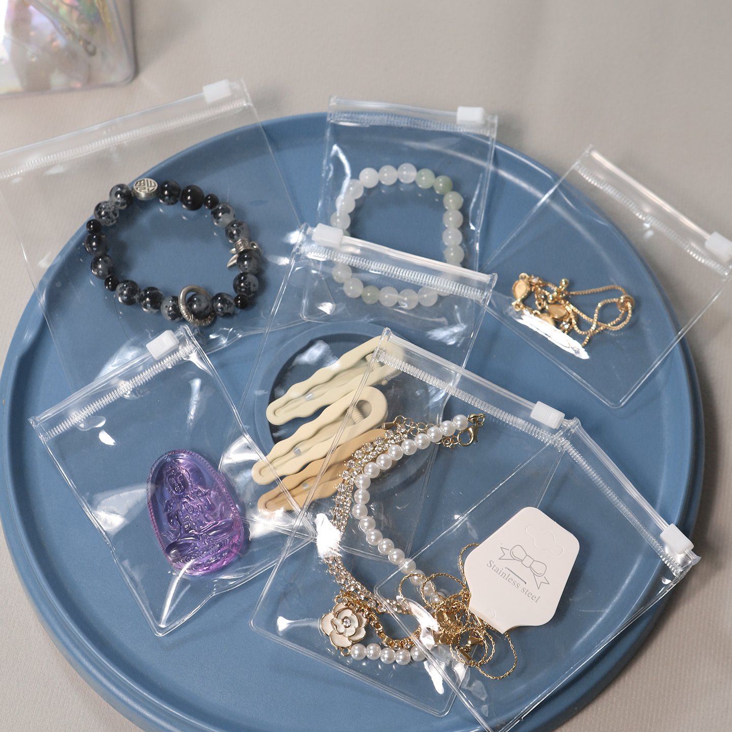 PVC vs EVA jewelry packaging bags: clear PVC pouches holding bracelets and necklaces