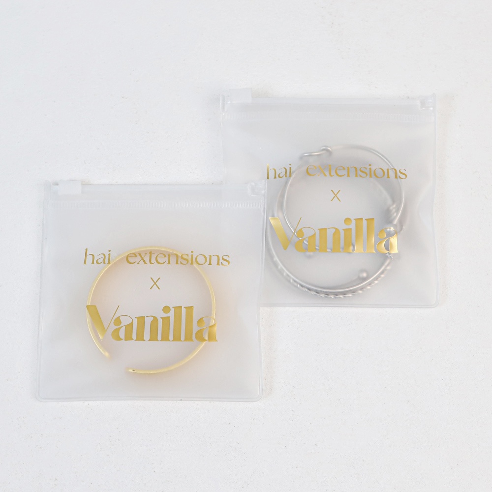 Frosted EVA jewelry pouches featuring gold custom logos, holding metal bracelets for premium retail presentation.