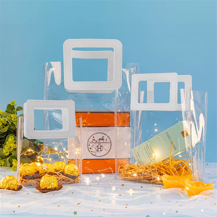 Clear custom PVC tote bags displaying luxury cosmetics and chocolate gift sets for boutique brands