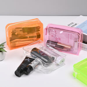 Transparent heavy-duty PVC cosmetic bags holding toiletry bottles, illustrating the high gloss clarity and rigid shape retention of thicker 0.10 mm to 0.50 mm PVC film.