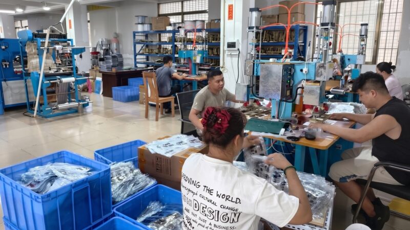 Guangdong Minghe Packing factory workers inspecting and packing custom plastic zipper pouches.